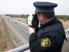 Northumberland OPP Constable Kevin McAllister using a device to clock the speed of the drivers from a bridge overlooking Highway 401. (Pete Fisher/QMI Agency)