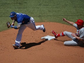 Brett Lawrie of the Toronto Blue Jays gets the force out at second base to end the fourth inning during MLB game action as Peter Bourjos of the St. Louis Cardinals slides on June 7, 2014 at Rogers Centre. (Tom Szczerbowski/Getty Images/AFP)