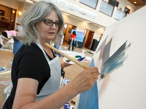 Ann Pendrigh-Nguyen paints during Brushstrokes for the Brave, held at Great West Chrysler in Edmonton, Alta., Saturday June 7, 2014. The event saw 110 paintings made by amateur and professional artists to be installed at the Little Warriors Be Brave Ranch. Ian Kucerak/Edmonton Sun/QMI Agency