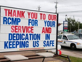 A Royal Canadian Mounted Police (RCMP) vehicle drives past one of many signs showing support for the RCMP officers in Moncton, New Brunswick June 7, 2014. REUTERS/Christinne Muschi