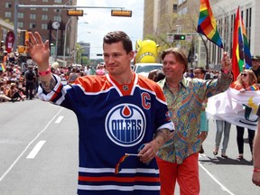 Oilers' Andrew Ference and Thomas Lukaszuk wave to the crowds during the Pride Parade in downtown Edmonton, Alta., on Saturday, June 7, 2014.  Perry Mah/ Edmonton Sun/ QMI Agency