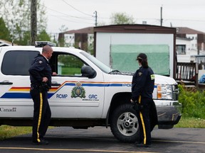Royal Canadian Mounted Police (RCMP) officers continue surveillance on a home in a trailer park  in Moncton, New Brunswick June 7, 2014. (REUTERS/Christinne Muschi)