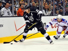 Los Angeles Kings right winger Dustin Brown controls the puck ahead of New York Rangers defencemen Ryan McDonagh (27) and Dan Girardi (5) in the second overtime period during Game 2 of the Stanley Cup. (USA Today Sports)