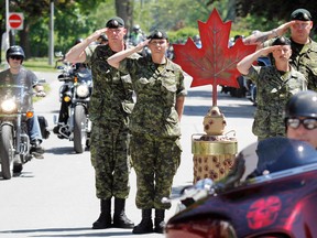 Some of the 2,000 motorcyclists participating in the sixth annual Heroes Highway Ride and Rally depart 8 Wing/CFB Trenton, Ont. as Warrant Officer Renee Groves of 21 Electrical Warfare Regiment at CFB Kingston, Ont. (second from left) and three other members of the unit salute alongside the memorial monument 'Leopard C1 Badger CFR 81657' Saturday, June 7, 2014. - Jerome Lessard/The Intelligencer/QMI Agency