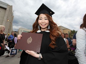 Ekaterina Balburova, a student from Russia, poses with her commerce degree following a convocation ceremony at the University of Manitoba on Wed., June 5, 2014. (Kevin King/Winnipeg Sun/QMI Agency)
