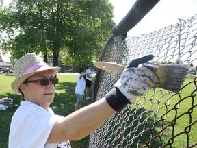 Ben Leeson/The Sudbury Star
Gabby Laberge, a members of St. Kevin's Parish, paints a fence at a baseball diamond in Hanmer as part of Elevate: Love in Motion, on Saturday.