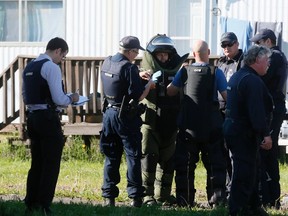 A Royal Canadian Mounted Police (RCMP) officer from the Explosive Disposal Unit (EDU) has gloves put on his hands before entering, according to local media, the home of Justin Bourque at a trailer park in Moncton, N.B., June 8, 2014. REUTERS/Christinne Muschi