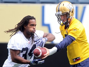 Winnipeg Blue Bombers running back Paris Cotton (left) takes a handoff from quarterback Drew Willy during a walkthrough on Sunday in advance of Monday night's exhibition game against Toronto. (Brian Donogh/Winnipeg Sun)