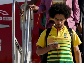 Cameroon player Benoit Assou Ekotto leaves the plane after landing in Galeao Aerial Base ahead of the World Cup in Rio de Janeiro June 9, 2014. (REUTERS/Ricardo Moraes)