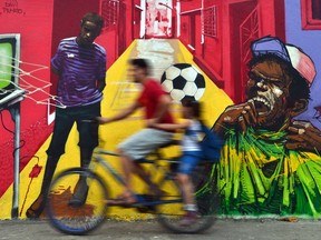 A man rides his bicycle in front of a mural painting in Rio de Janeiro, Brazil, June 9, 2014. (CHRISTOPHE SIMON/AFP)