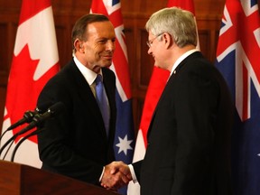 Prime Minister Stephen Harper (R) and his Australian counterpart Tony Abbott shake hands at a joint news conference on Parliament Hill in Ottawa June 9, 2014. REUTERS/Patrick Doyle