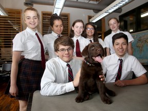 Students at Leahurst College in Kingston pose with Lawrence, a puppy being trained to be a service dog for Kingston 4 Paws Academy. The students are, front, from left, Ryan McIver and Josh Sequillion, rear, from left, Emily Kate Taylor, Waverley Mulligan, Eden Bibic, Michelle deOliveira and Isla Turcke.  IAN MACALPINE/THE WHIG-STANDARD