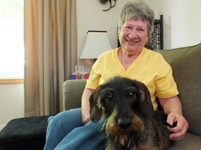 Faye Finlayson, sitting with her dog Oliver, smiles, showing off the pearly whites she had fixed when a generous dentist came to her rescue. BRENT BOLES / THE OBSERVER / QMI AGENCY