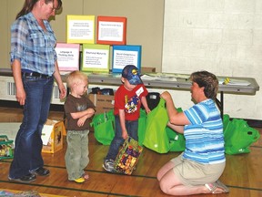 Mom Susan Heather brought her sons Weston Messerli, 3, and Laine Messerli, 5, to a developmental checkup held at Vulcan Prairieview Elementary on June 6. Here, Kim Daniells, resource co-ordinator for the Vulcan County Early Childhood Development Coalition, gives Laine a bag packed with informational resources on local organization like the Rainbow Literacy Society.  
Simon Ducatel Vulcan Advocate