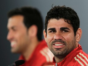 Spain's striker Diego Costa (R) listens next to team mate Sergio Busquest during a news conference ahead of the 2014 World Cup in Curitiba, June 10, 2014. (REUTERS/Henry Romero)