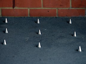A picture shows short metal spikes installed outside the entrance of a building in London. Montreal Mayor Denis Coderre ordered spikes outside of a local bookshop to be removed. 

AFP PHOTO / CARL COURT