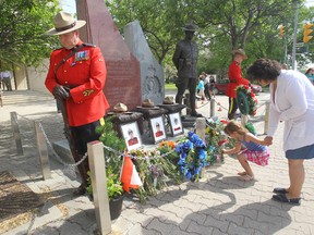 RCMP held a brief memorial service honoring the three officers killed in Moncton last week. Four and a half year old Abigail placed some flowers in front of the fallen officers photos, she was with her mother, Jacqui Bell. Tuesday,  June 10, 2014.  Chris Procaylo/Winnipeg Sun/QMI Agency