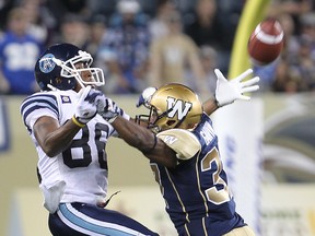 Toronto Argonauts wide receiver K.J. Stroud (l) misses a pass due to pass interference from Winnipeg Blue Bombers defensive back Michael Ray Garvin on June 9.
