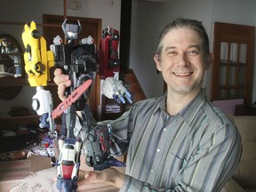 Matthew Williams holds one of the largest models of his Empyricons, one-of-a-kind, custom-made action figures based on the Transformers series. He has made hundreds of the characters in the past few years. MICHAEL LEA\THE WHIG-STANDARD