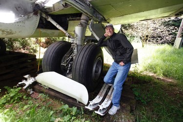 Bruce Campbell leans on a tyre of his Boeing 727 home in the woods outside the suburbs of Portland, Oregon May 21, 2014. In 1999, the former electrical engineer had a vision: To save retired jetliners from becoming scrap metal by reusing them. Campbell, 64, is one of a small number of people worldwide who have transformed retired aircraft into a living space or other creative project, although a spokesman for the Aircraft Fleet Recycling Association was unable to say precisely how many planes are re-used this way. Picture taken May 21.  REUTERS/Steve Dipaola  (UNITED STATES - Tags: SOCIETY TRANSPORT REAL ESTATE)