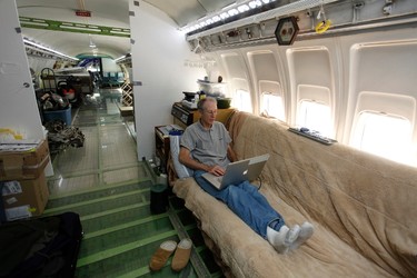Bruce Campbell sits on his futon bed while using a laptop in his Boeing 727 home in the woods outside the suburbs of Portland, Oregon May 21, 2014. In 1999, the former electrical engineer had a vision: To save retired jetliners from becoming scrap metal by reusing them. Campbell, 64, is one of a small number of people worldwide who have transformed retired aircraft into a living space or other creative project, although a spokesman for the Aircraft Fleet Recycling Association was unable to say precisely how many planes are re-used this way. Picture taken May 21.  REUTERS/Steve Dipaola
