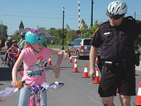 Ten-year-old Shaylin Brown of St. Thomas learns proper hand signals from Elgin OPP Const. Troy Carlson during the Downtown Bike Festival held Saturday.