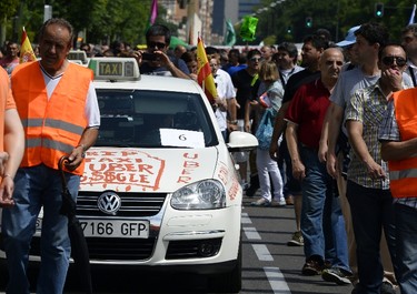 Taxi drivers stage a strike action in protest of unlicensed taxi-type-services in central Madrid on June 11, 2014. Taxi drivers in London, Paris, Madrid and other European capitals plan to bring chaos to the streets today in protest against unlicensed mobile car-hailing services such as Uber which have shaken up the industry.  (AFP PHOTO/GERARD JULIEN)