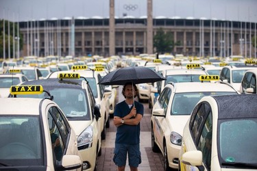A man attends a Europe-wide protest of licensed taxi drivers, denouncing taxi hailing apps that are feared to flush unregulated private drivers into the market, in front of the Olympic stadium in Berlin, June 11, 2014. REUTERS/Thomas Peter