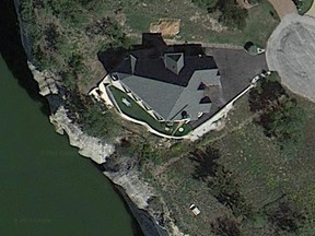 A luxury $800,000 Texas home perched on a lakeside bluff was poised to plunge into the water below on Wednesday after the ground under its foundation eroded. This photo shows the house before the land gave way.
(Screenshot from Google Maps)