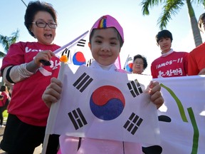 A fan holds the South Korean flag as she welcomes South Korea's national football team at the Bourbon Hotel in Foz do Iguacu, Parana, on June 11, 2014 where the team will be staying during the 2014 FIFA World Cup in Brazil. (AFP PHOTO/JUNG YEON-JE)