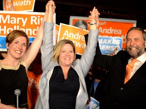 Ontario NDP Leader Andrea Horwath is flanked by Kingston and the Islands candidate Mary Rita Holland and federal leader Thomas Mulcair during a  campaign stop at the Toucan pub in Kingston on Wednesday, the day before Thursday's provincial election. ALEX PICKERING/THE WHIG-STANDARD