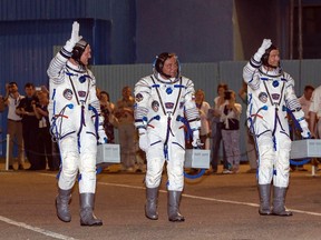 International Space Station crew members (L-R) Alexander Gerst of Germany, Maxim Surayev of Russia and Reid Wiseman of the U.S. walk after donning space suits at the Baikonur cosmodrome May 28, 2014. (REUTERS/Shamil Zhumatov)