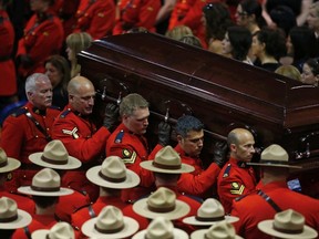 Pallbearers carry the casket of one of three Royal Canadian Mounted Police officers who were killed last week during a regimental funeral in Moncton, New Brunswick, June 10, 2014. (REUTERS)