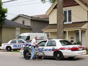 Police vehicles surround a home at 157 Mill St. Thursday as officers probe a Wednesday night incident that left one woman seriously hurt and a second facing assault charges. (DEREK RUTTAN, The London Free Press)