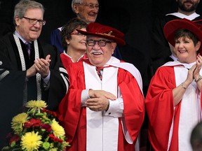 John (c) and Bonnie Buhler stand on the dias with U of W president Lloyd Axworthy (l) after receiving Honourary Doctor of Laws degrees at the University of Winnipeg convocation in Winnipeg, Man. Thursday June 12, 2014. The U of W Students' Association is upset because Buhler was guilty of unfair labour practices in 2000.
Brian Donogh/Winnipeg Sun/QMI Agency