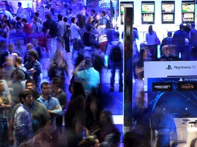 Attendees play video games in the Sony Playstation booth at the 2014 Electronic Entertainment Expo, known as E3, in Los Angeles, California June 11, 2014. Picture taken with a long exposure.  REUTERS/Kevork Djansezian