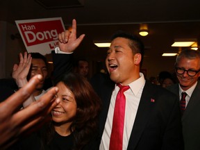 Liberal Han Dong arrives with his wife, Sophia, and federal Liberal candidate Adam Vaughan to his victory party in the Trinity-Spadina late Thursday. (STAN BEHAL/Toronto Sun)