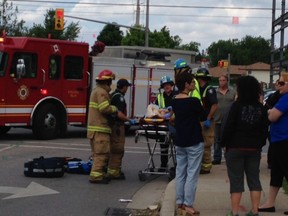 Paramedics take away a woman on a stretcher after a vehicle involved in a collision struck three pedestrians at Southdale Rd. E. and Ernest Ave. on Friday. CHERYL CHUTE / THE LONDON FREE PRESS