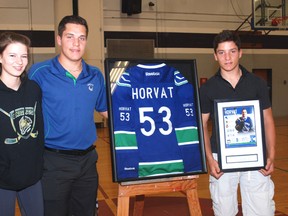 Kristen Kovacs, cousin of Bo Horvat, joined him Friday for the unveiling of a framed hockey jersey that will be hung at West Elgin Secondary School. On the right is Bo's brother, Cal Horvat.