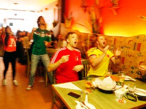 Fans cheer as they watch the World Cup game between Mexico and Cameroon at La Mexicana restaurant on Yonge St on Friday. (MICHAEL PEAKE, Toronto Sun)