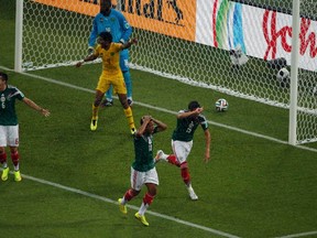 Mexico's Hector Herrera, Giovani Dos Santos and Hector Moreno react after their goal was disallowed during the 2014 World Cup Group A soccer match between Mexico and Cameroon at the Dunas arena in Natal June 13, 2014. (REUTERS/Carlos Barria)