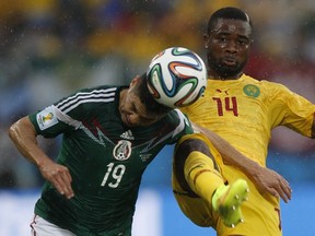 Mexico's Oribe Peralta (L) and Cameroon's Aurelien Chedjou fight for the ball during their 2014 World Cup Group A soccer match at the Dunas arena in Natal June 13, 2014. (REUTERS/Toru Hanai)