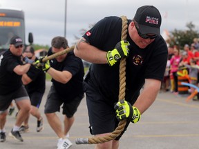 Belleville volunteer firefighter Mitch Hayes leads the fire department's winning team in Saturday's Pull for Kids fundraiser outside Belleville's Best Buy store.