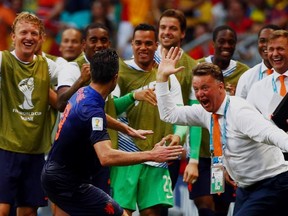 Robin van Persie of the Netherlands (front) celebrates his goal against Spain with coach Louis van Gaal during their 2014 World Cup Group B soccer match at the Fonte Nova arena in Salvador June 13, 2014.  (REUTERS/Michael Dalder)
