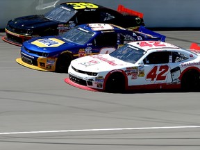 Ryan Sieg (closest to wall), Chase Elliott and Kyle Larson 
Kyle Larson go three wide during the NASCAR Nationwide Series race at Michigan International Speedway on Saturday. (AFP)