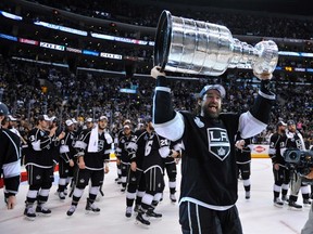 Los Angeles forward Justin Williams hoists the Stanley Cup after the Kings defeated the New York Rangers on Friday night. (Gary A. Vasque/-USA TODAY Sports)