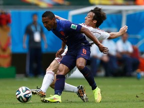 Jonathan de Guzman of the Netherlands (front) fights for the ball with Spain's David Silva during their 2014 World Cup Group B soccer match at the Fonte Nova arena in Salvador June 13, 2014. (REUTERS/Marcos Brindicci)