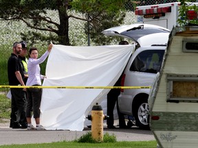 A body of a man is removed from the scene after he was fatally hit by his own truck that was being stolen, near 29 Street and 116A Avenue on Friday. (DAVID BLOOM/Edmonton Sun)