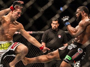 Rory MacDonald (left) blocks a kick from Tyron Woodley (right) during UFC 174 welterweight bout at Rogers Arena in Vancouver, B.C. on Saturday June 14, 2014. (Carmine Marinelli /QMI Agency)