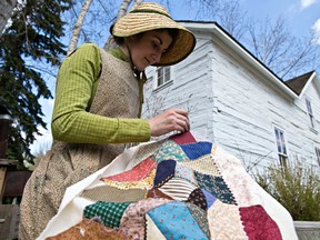 Hilary Twa gets in character as she quilts along 1885 Street during Fort Edmonton Park's season opener in Edmonton on May 19, 2014. Codie McLachlan/Edmonton Sun/QMI Agency